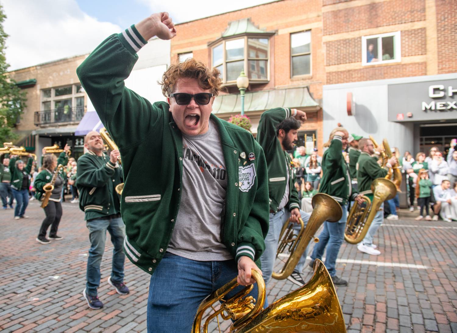 A member of the Marching 110 Alumni Band is amped to be back performing at the Homecoming Parade on Court Street.