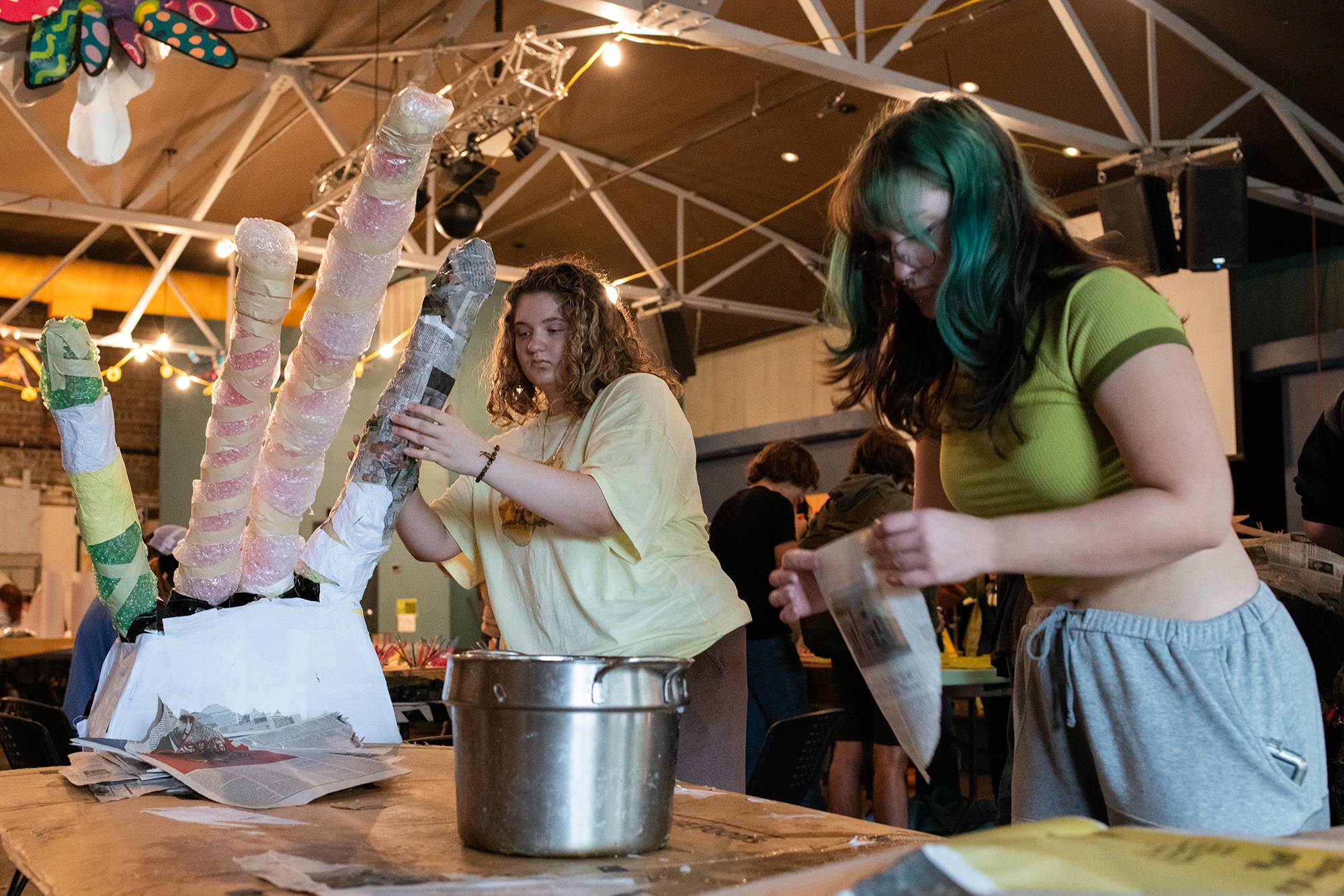 Members of an Ohio University learning community work together at the Central Venue to create paper mache pieces for a costume to be worn in the Honey for the Heart parade in Athens, Ohio.