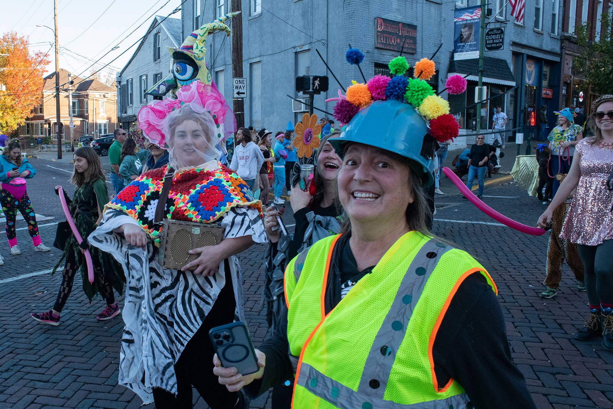 Participants in the 2022 Honey for the Heart parade dance their way down Court Street while “Bam Bam” by Sister Nancy plays from a hand crank speaker in Athens, Ohio.