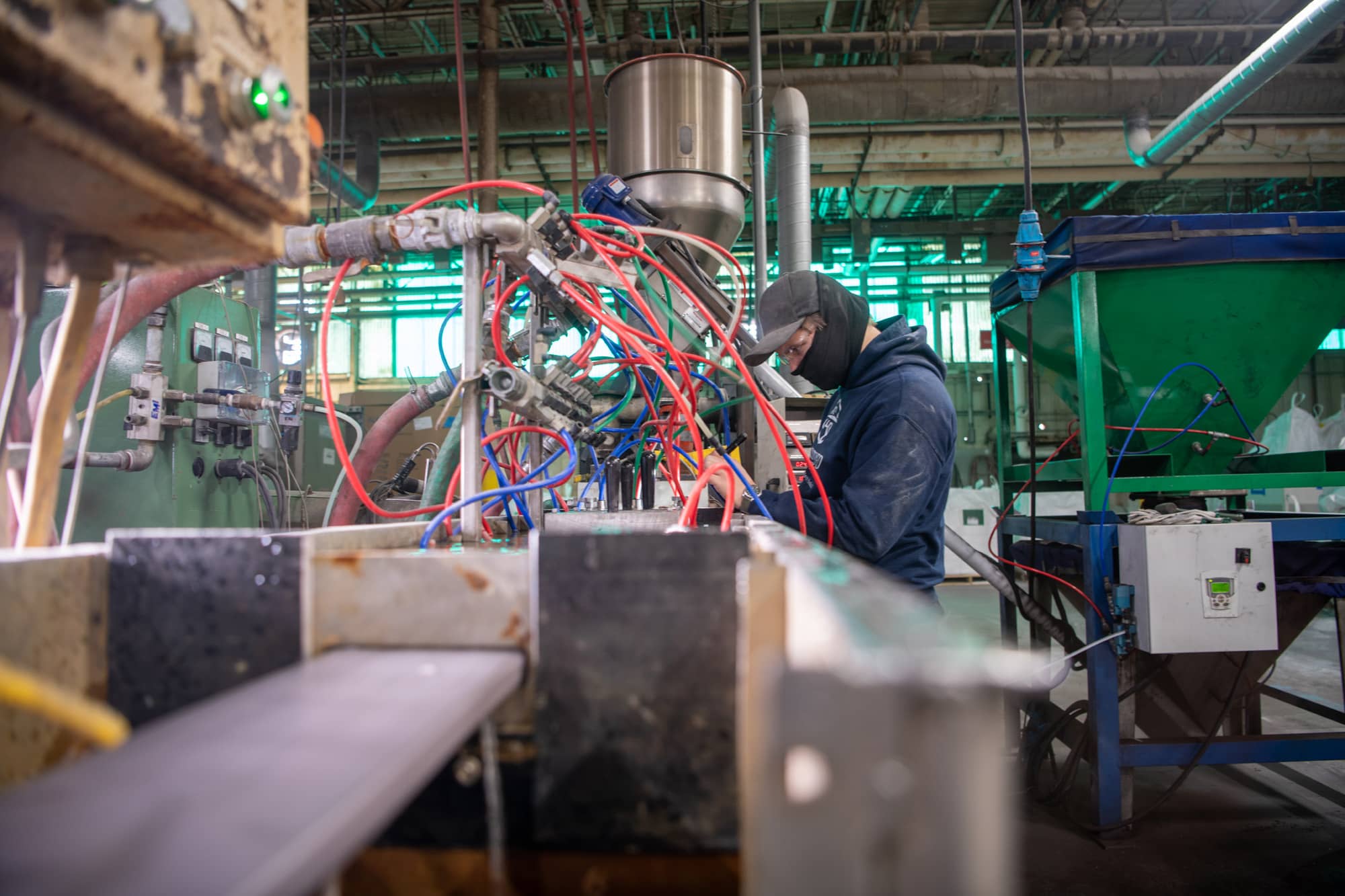 An employee of Engineered Profiles produces a deck board comprised mostly of coal waste.