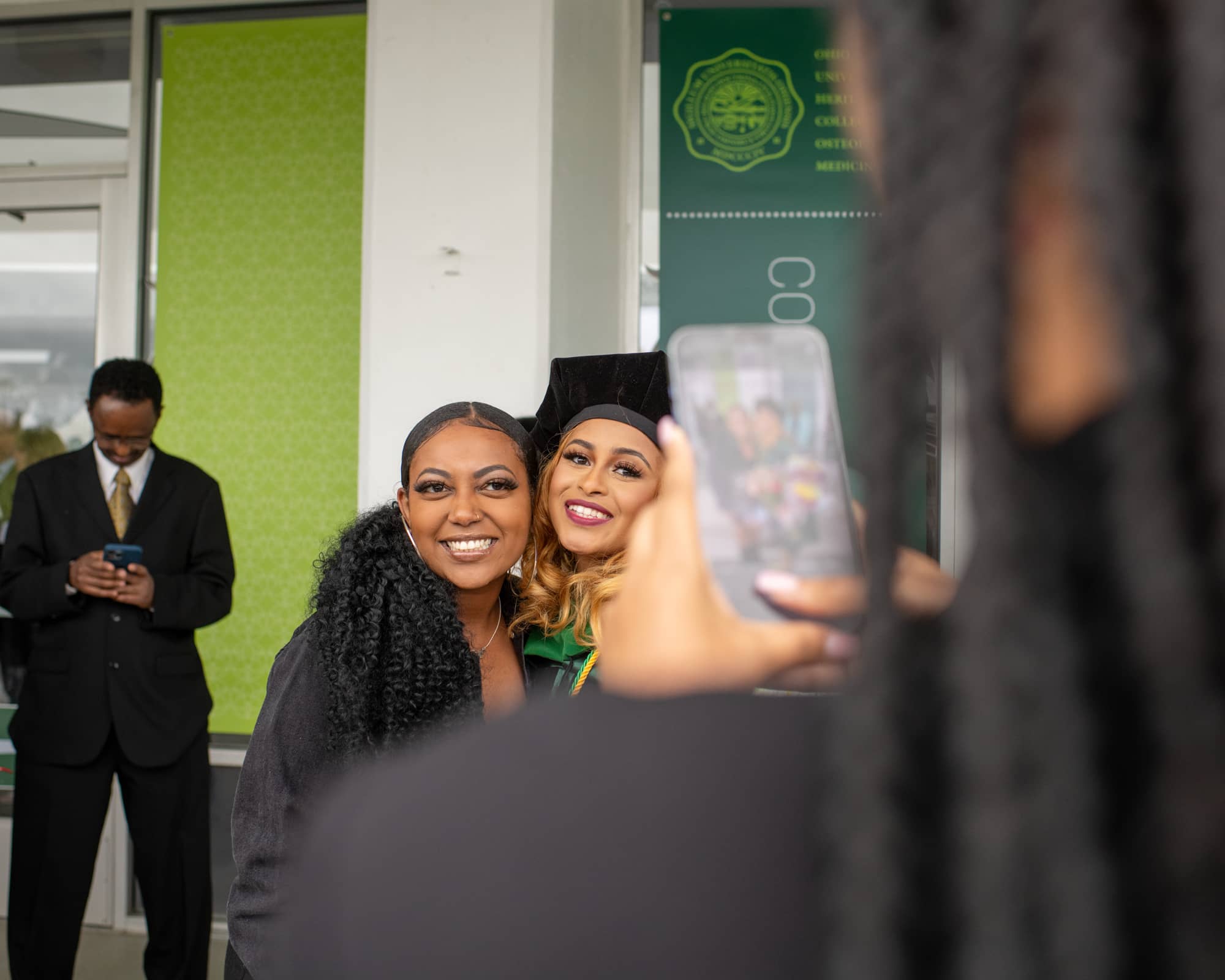 A Heritage College graduate poses for a photo with a supporter following commencement.