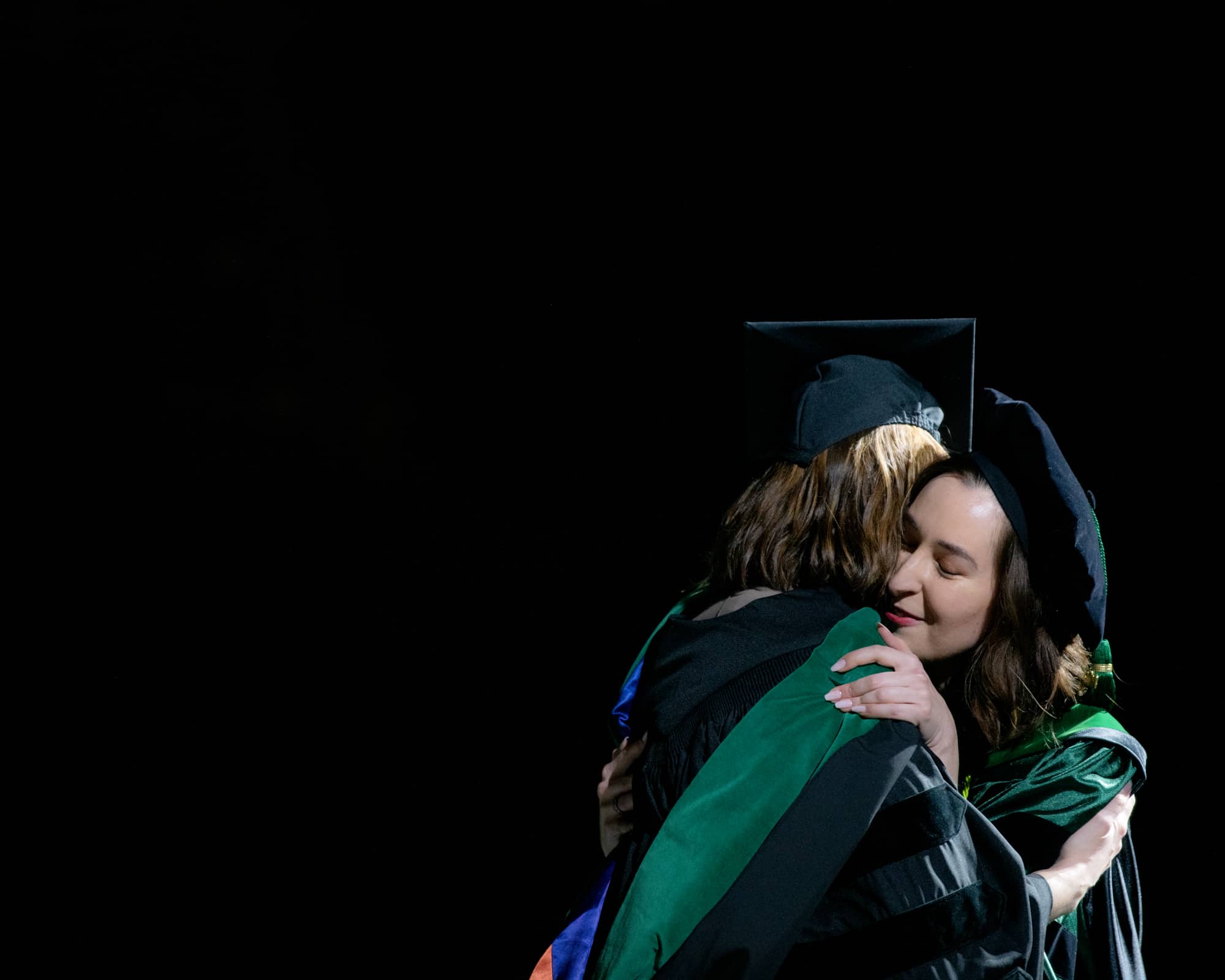 A Heritage College student is hugged by their mentor at commencement.