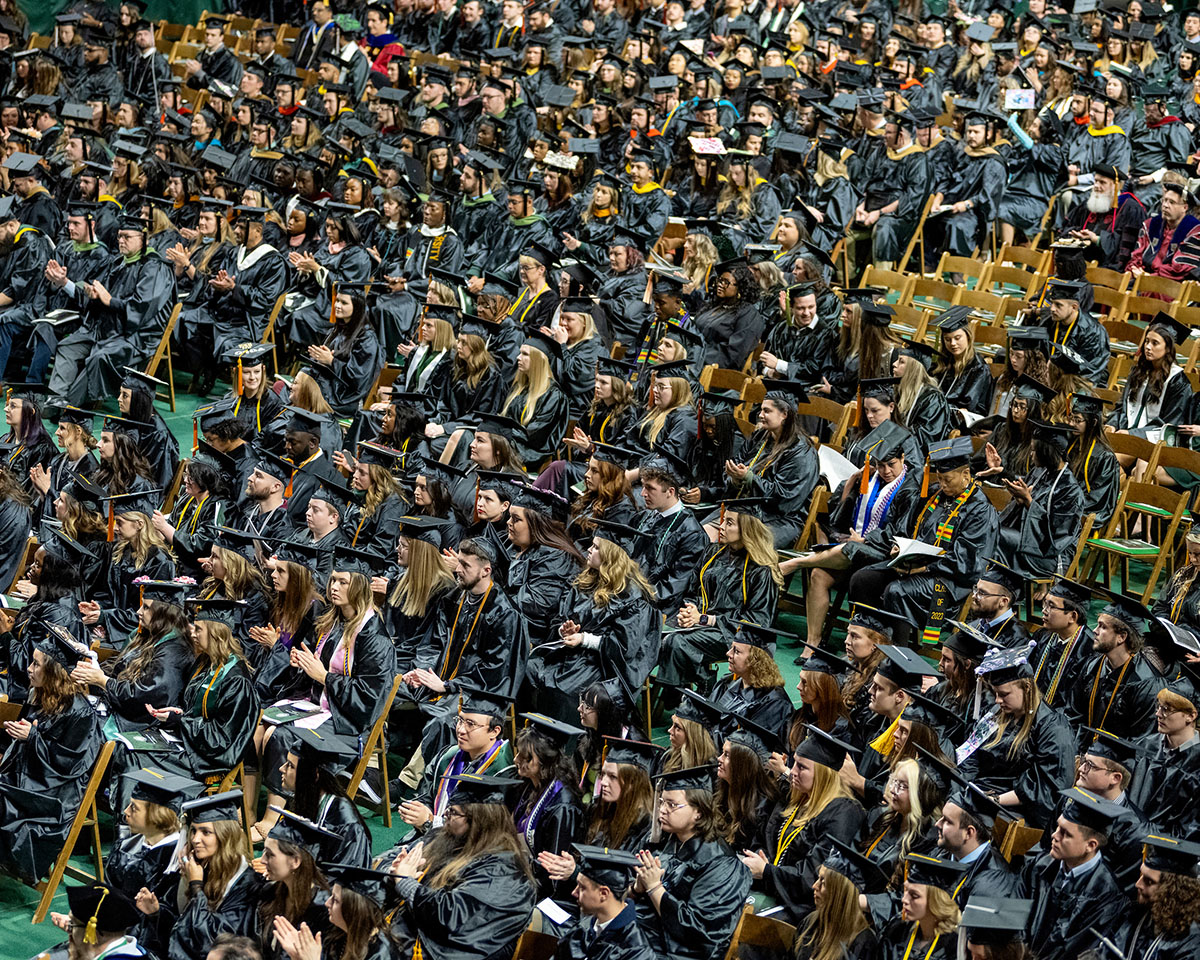 View from above of a group of graduates sits in the Convocation Center for the Fall 2023 commencement ceremony