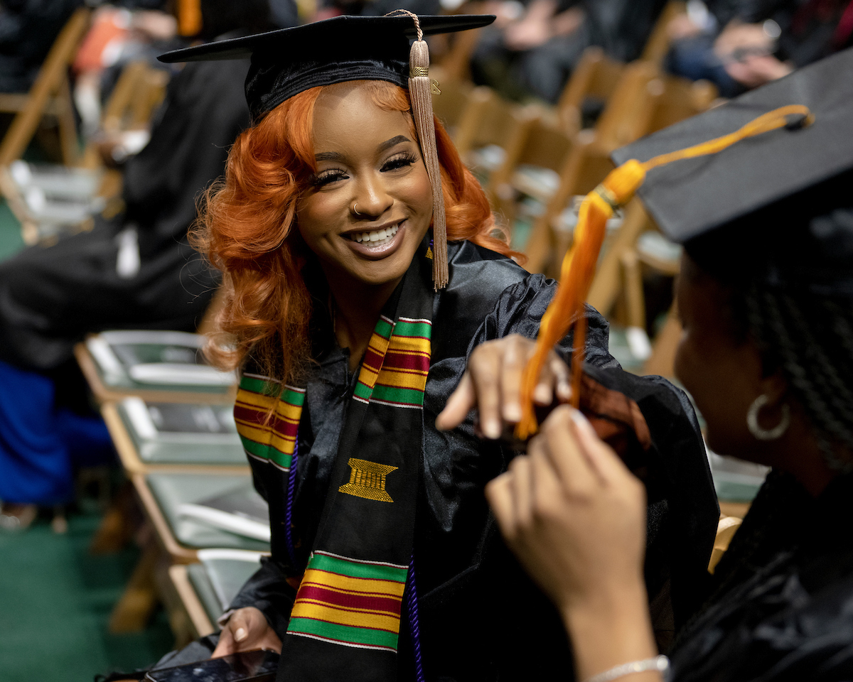 Seated female graduate moves tassle at the end of Fall 2023 Commencement ceremony