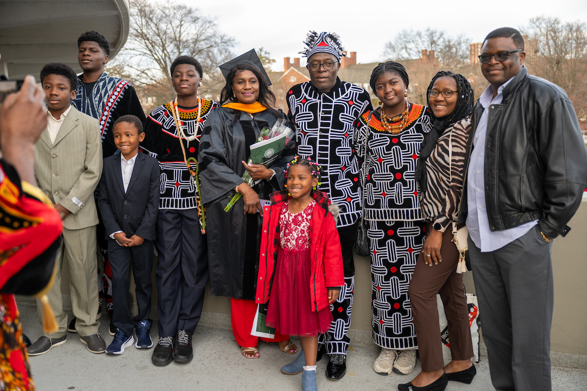 Graduate and family celebrate outside of the Convocation Center at Fall 2023 Commencement