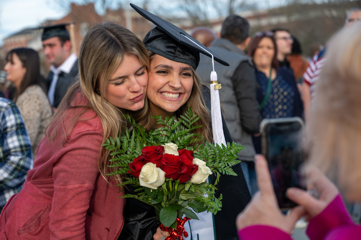 Graduate celebrates outside of the Convocation Center for Fall Commencement 2023