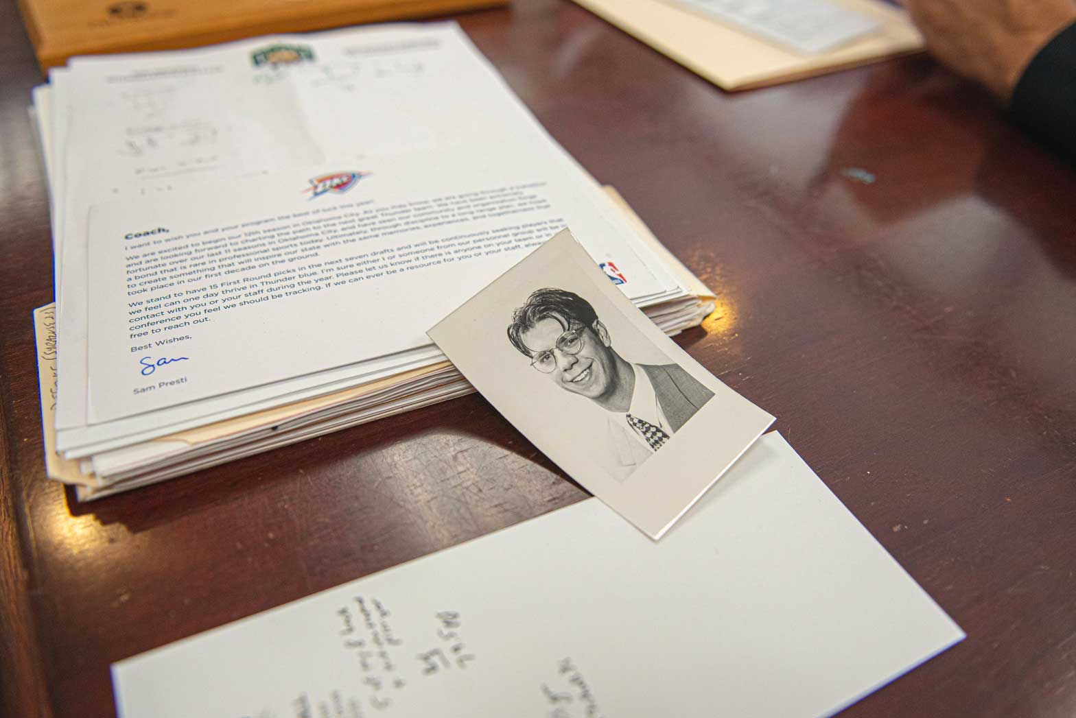A small portrait of young Coach Boals sitting next to papers on his desk.