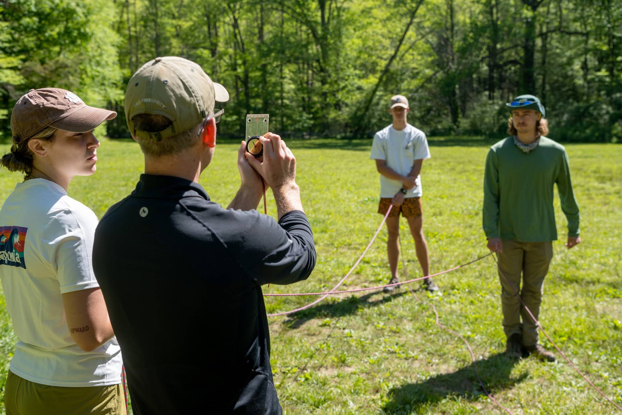 Associate Professor Andy Szolosi teaches students how to adjust their compasses for magnetic declination using climbing ropes as visual aides.