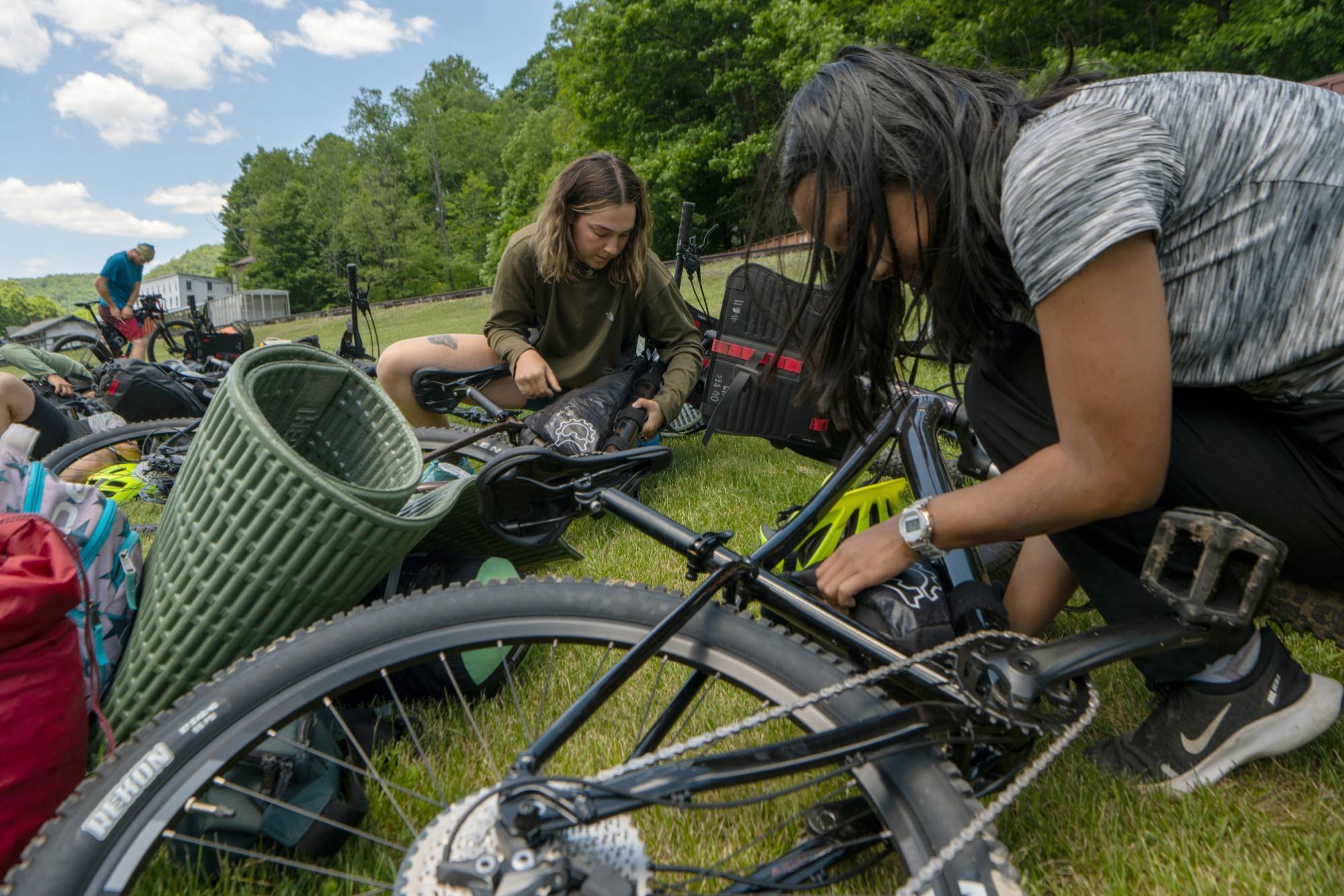 Autumn Warren (left) and Maya Snyder install bike-packing gear on their mountain bikes.