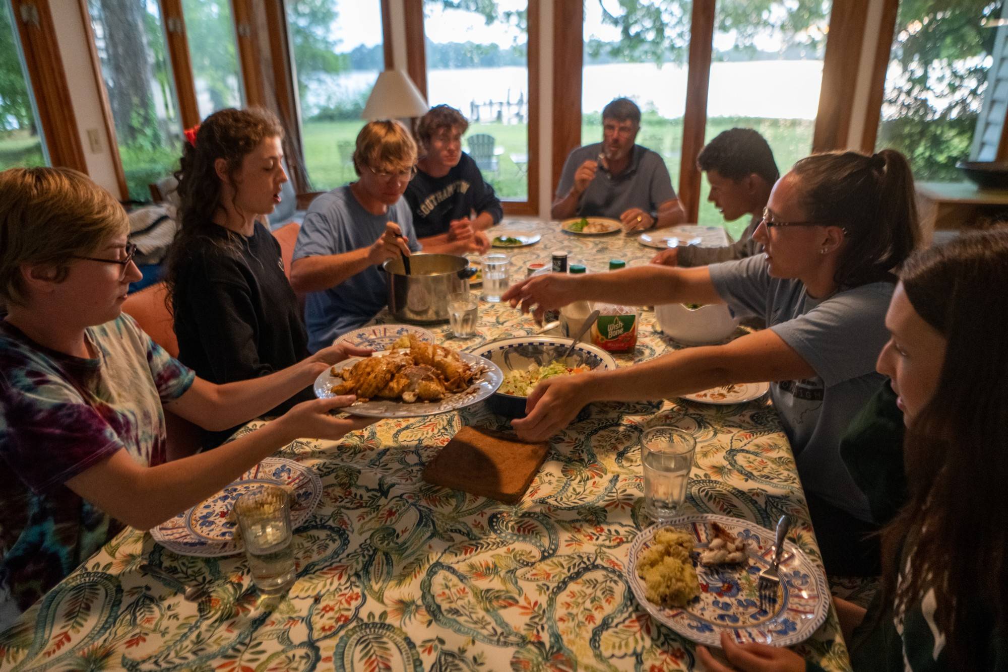 Students enjoy fresh caught snakehead fish family style at Roosenberg's home.