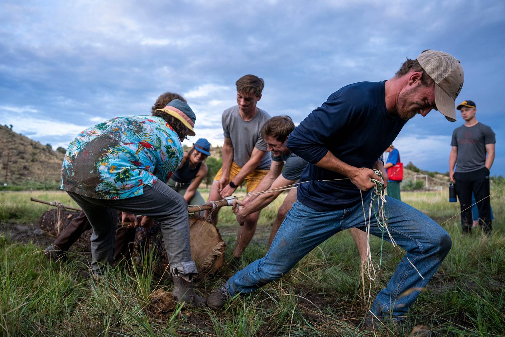 The Marketing and Photography Services Team at Philmont Scout Ranch work together to pull a log across a field at the Conservation Olympics on July 4, 2022, in Cimarron, N.M