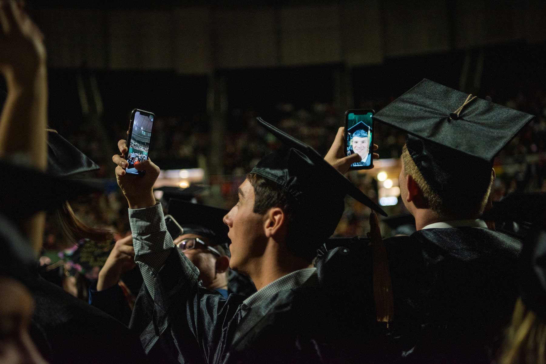 Graduating students take selfies in caps and gowns