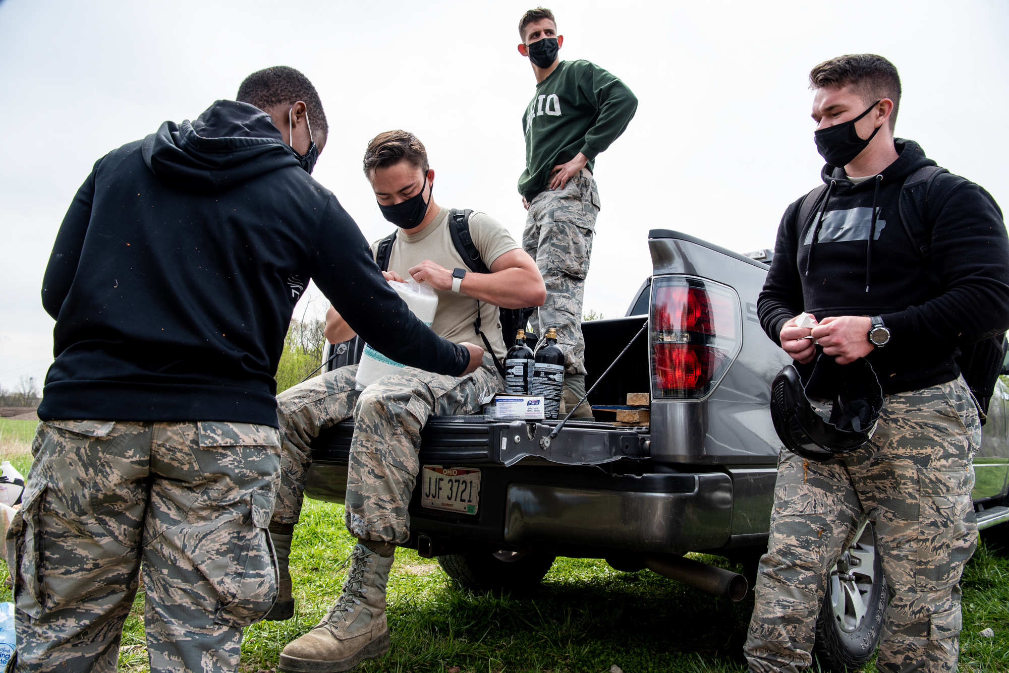 Air Force ROTC members gather behind a pickup truck after a training exercise
