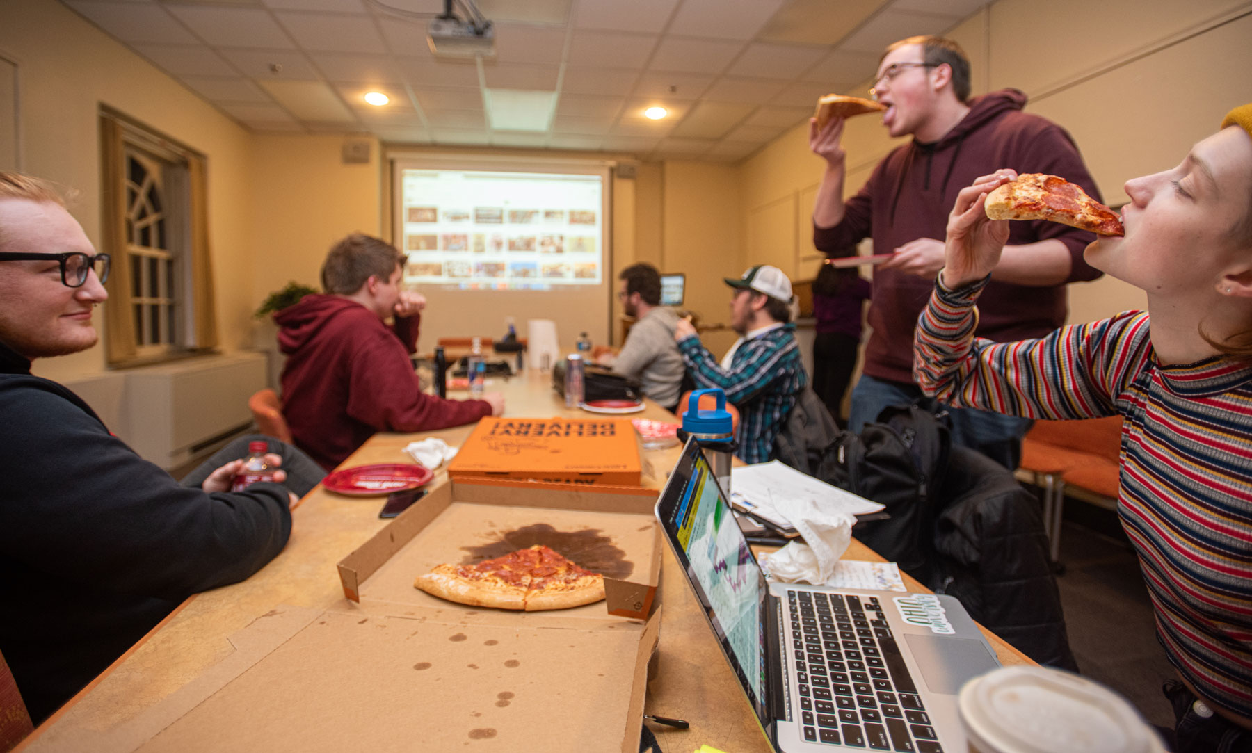 Students enjoying pizza during a planning session