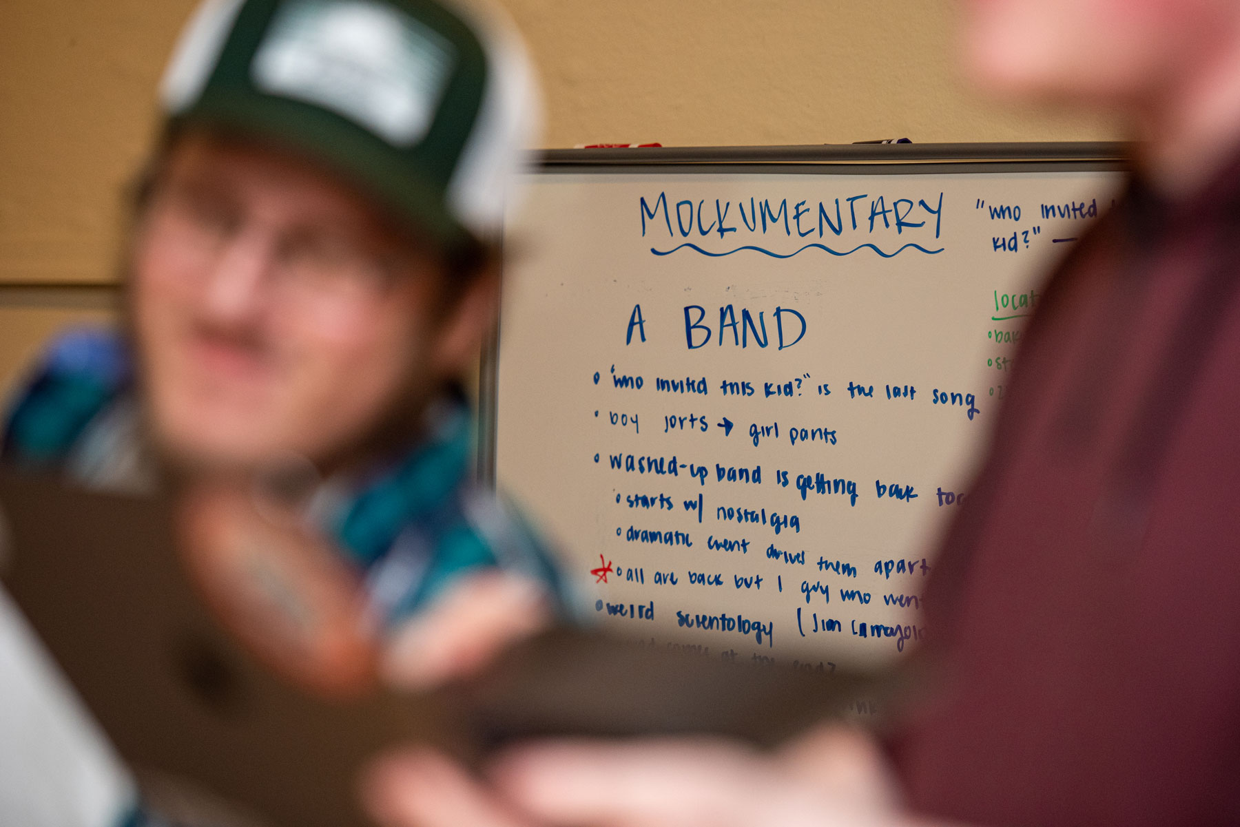 Out of focus faces in front of a focused whiteboard during a planning session