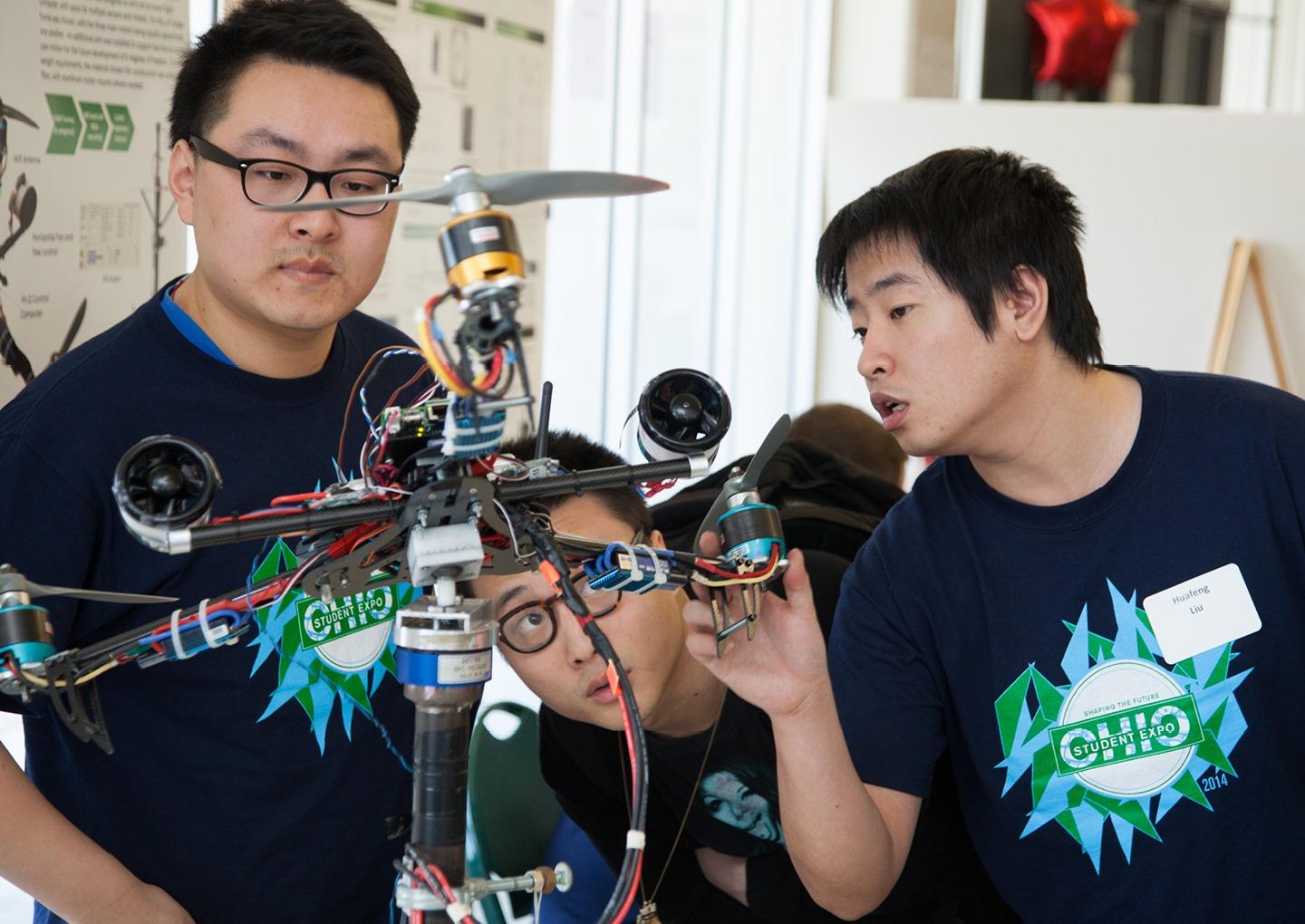 Huafeng Liu, BSEE’15, [RIGHT] explains the tricopter design his team built to classmates at the 2014 Student Research and Creative Activity Expo. Photo by Jonathan Adams