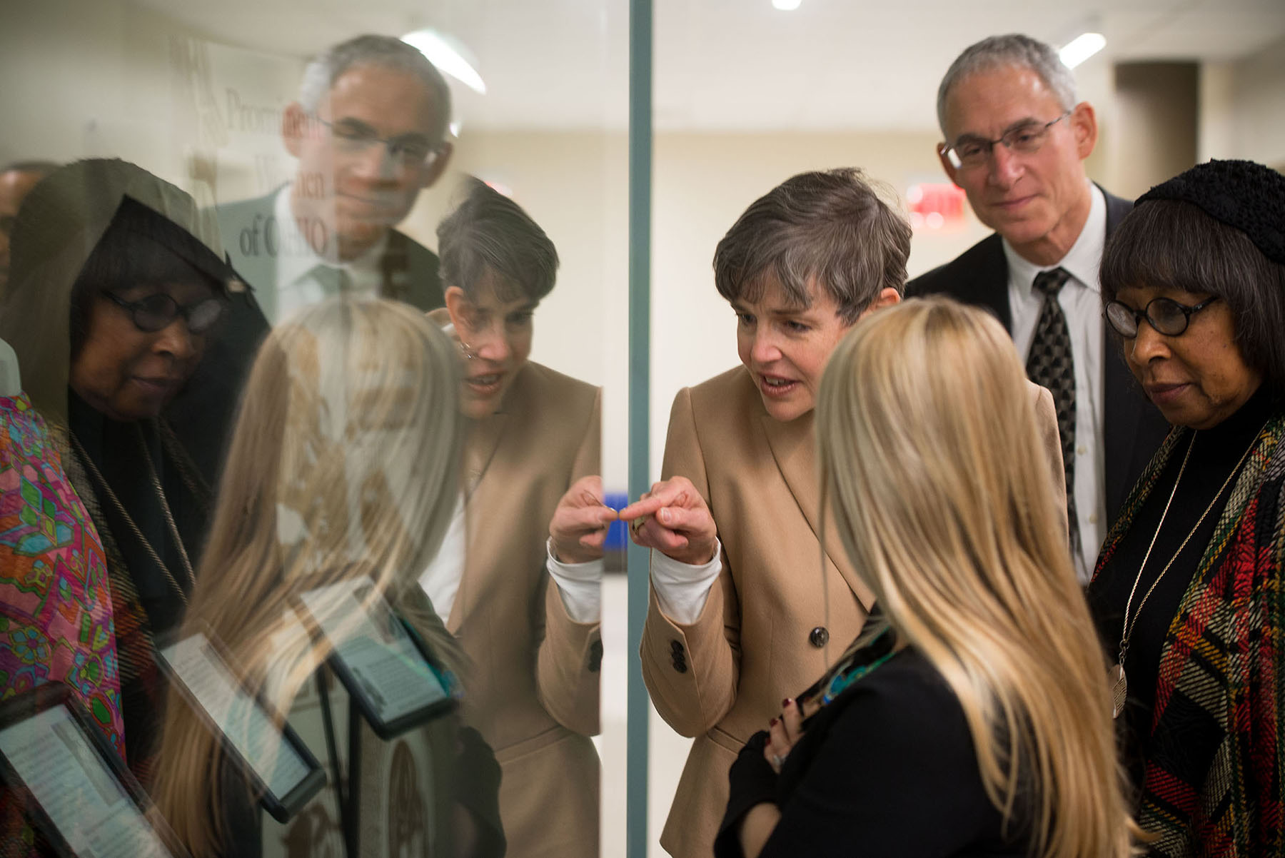 a woman points to an item in a glass display case while a man and two women observe
