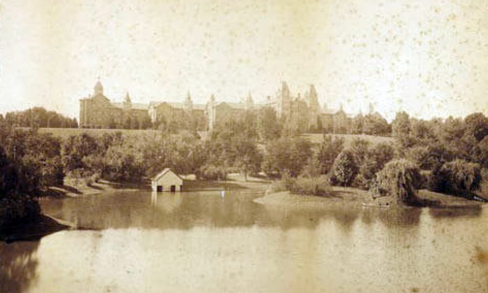 front facing view of the ridges. a large pond and trees with the buildings behind it