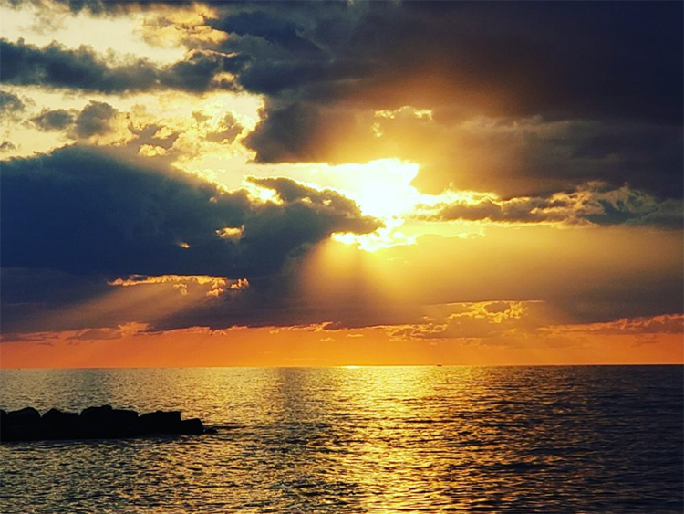 sunset over water with dark clouds