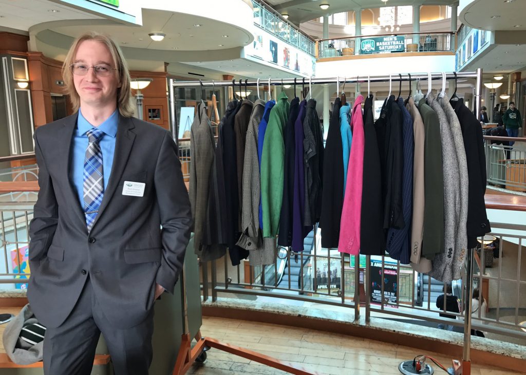 CLDC Graduate Assistant Zachary Graman proudly stands in front of select Career Closet inventory. Graman has led the Career Closet since its inception in 2015. Photo courtesy of the CLDC