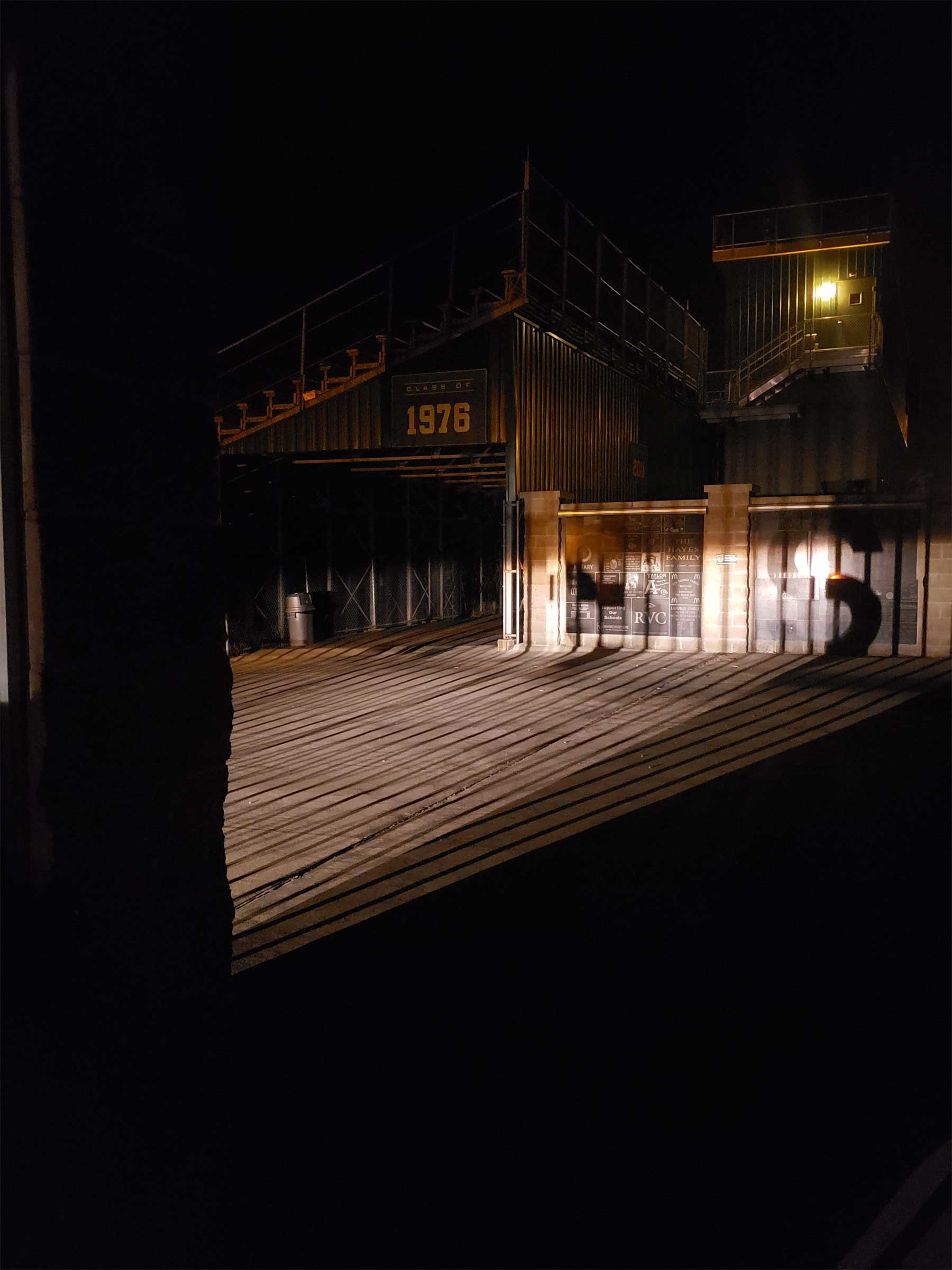 Light from inside makes shadow of bars across a street