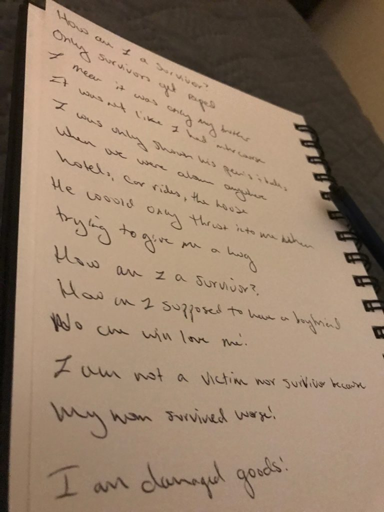 A white piece of paper, bound with a spiral, has the following written text: “How am I a survivor? Only survivors get raped. I mean it was only my brother. It wasn’t like I had intercourse. I was only shown his penis and balls when we were alone anywhere. Hotels, car rides, the house. He would only thrust into me when trying to give me a hug. How am I a survivor? How am I supposed to have a boyfriend No one will love me! I am not a victim nor survivor because my mom survived worse! I am damaged goods!