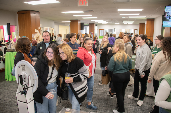 A crowd mingles in a large indoor space