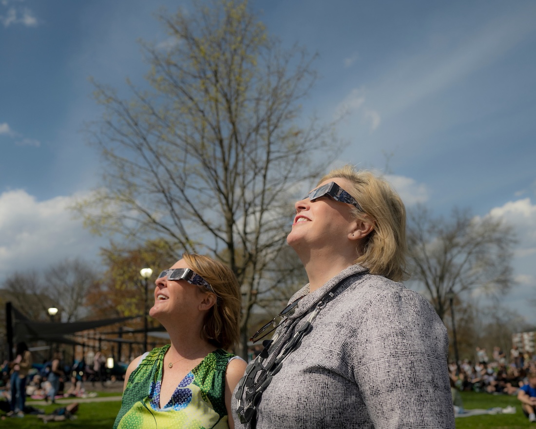 Wearing dark eclipse glasses, President Gonzalez gazes at the sky