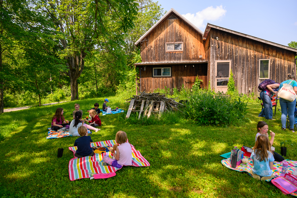 Multiple kids sitting for a picnic at Green Project Camp