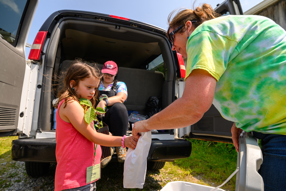 Camper looking into a bag with a counselor