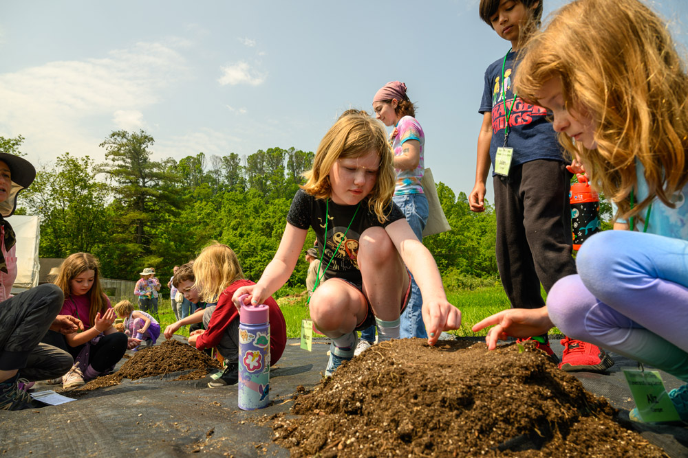 Campers looking through dirt for objects. 