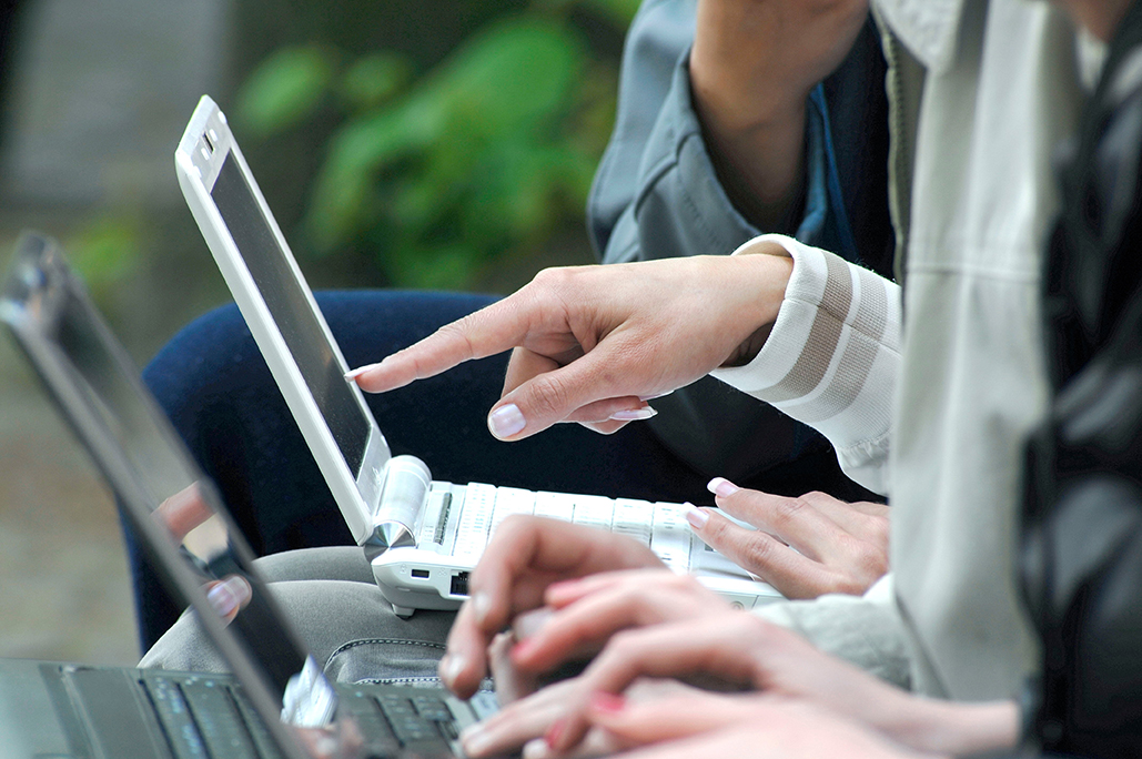 College students review information in front of their laptops