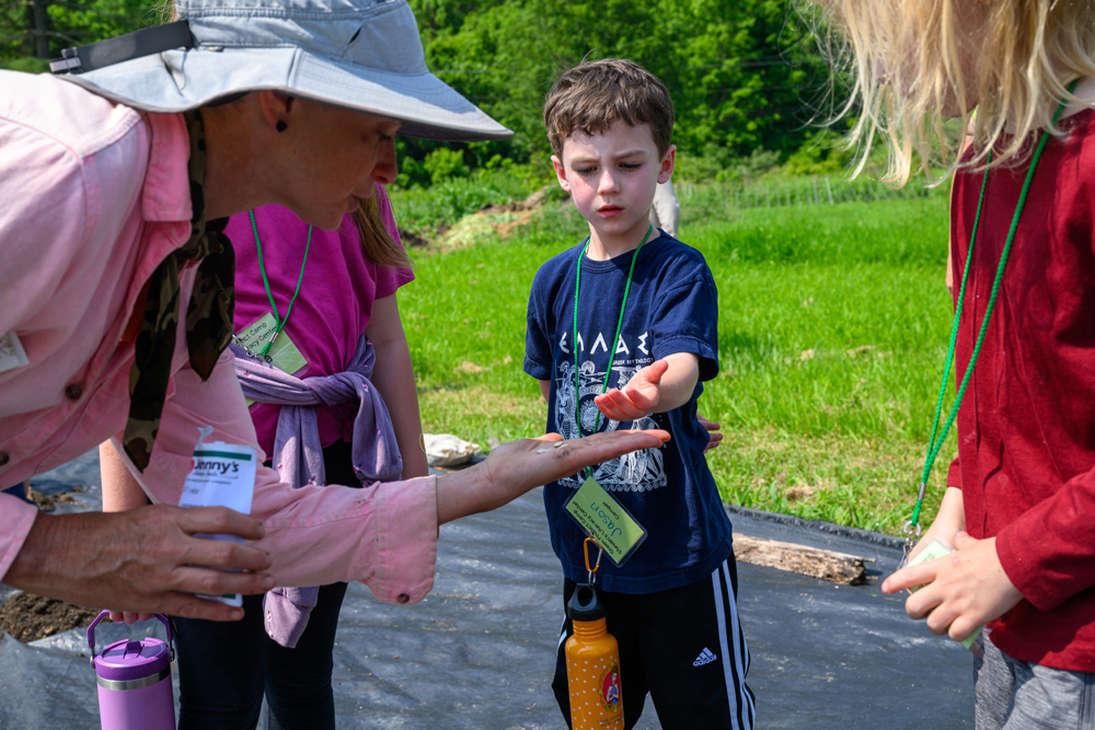 Camper holding an object that the counselor gave him.