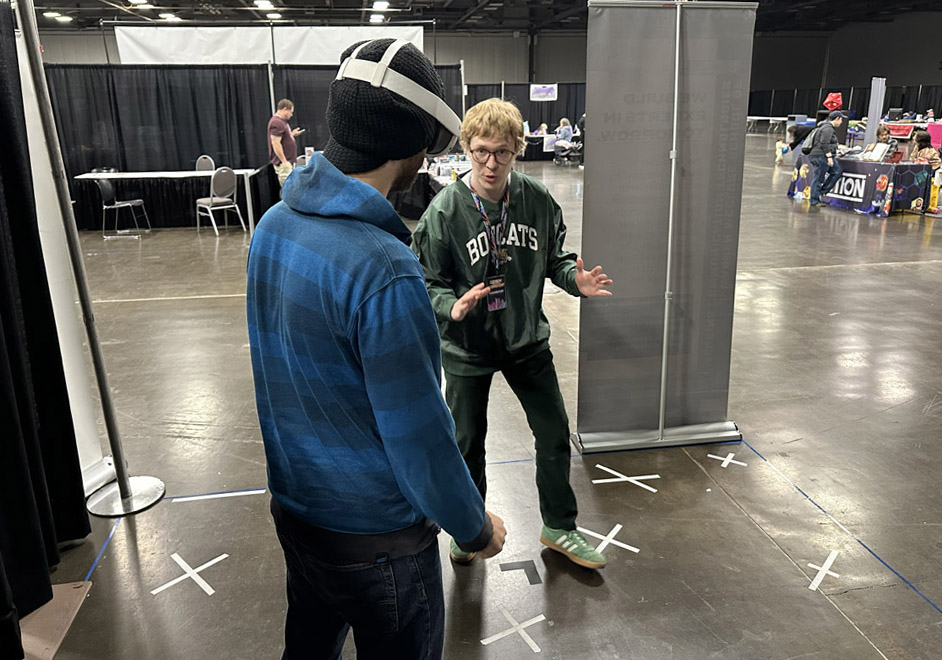 William Hamilton explaining Gnome Invasion to a convention attendee.