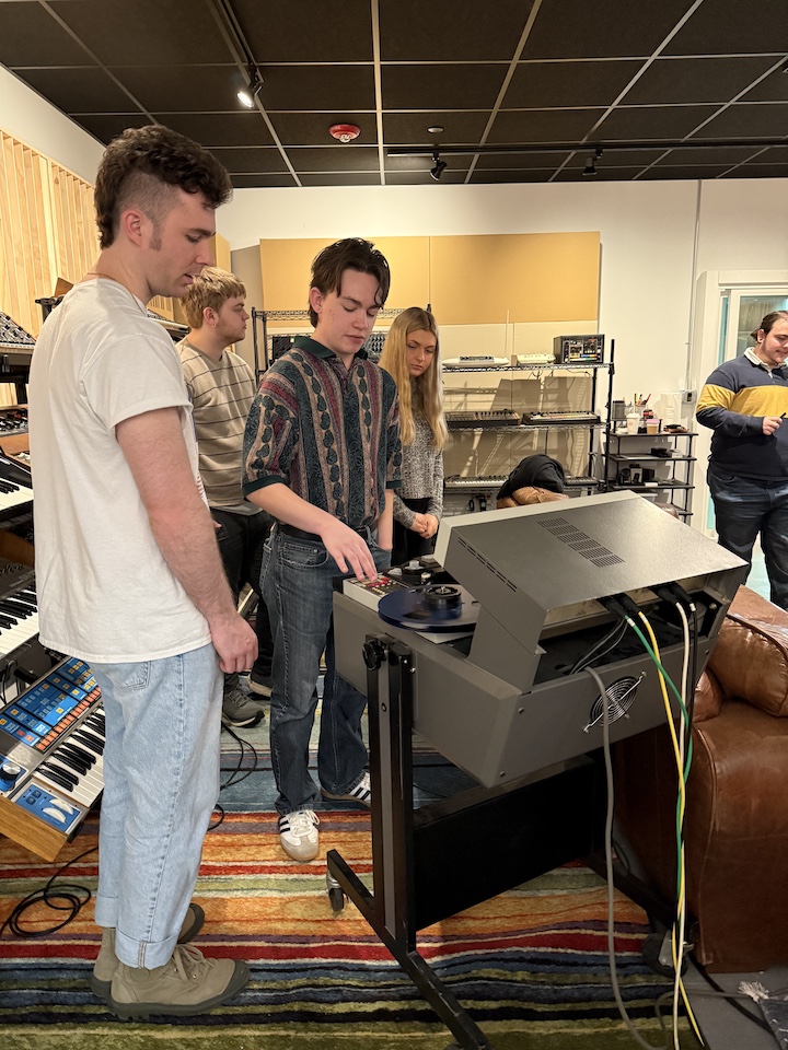 Students working with equipment in recording studio