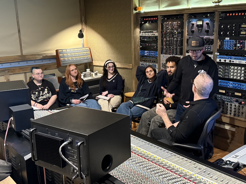 Students collaborating with industry professional in recording studio