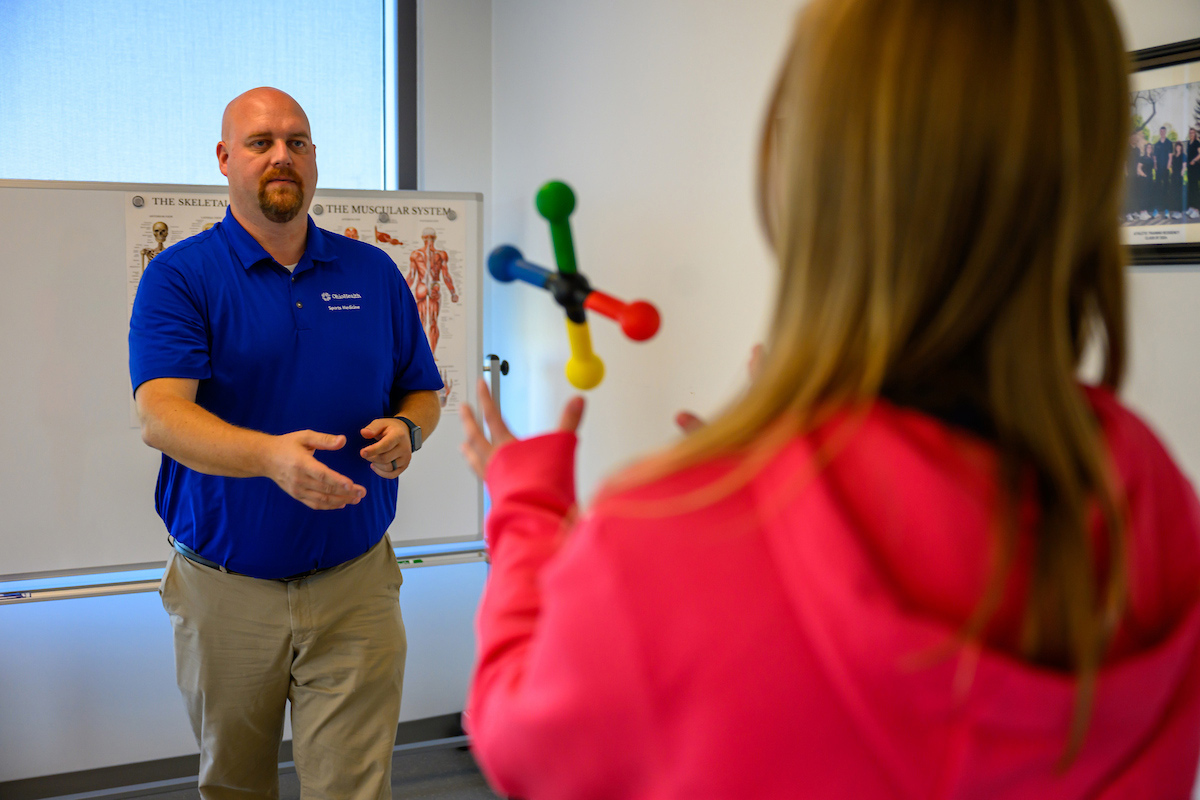 Ohio University pediatric athletic training program working with teen athlete on hand-eye coordination and reaction training.OHIO and OhioHealth 