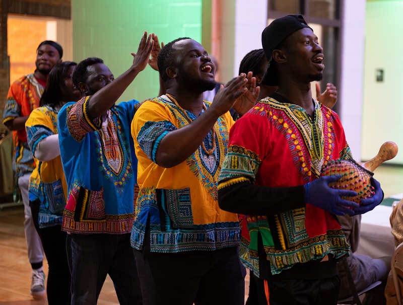 OHIO students wearing clothes from their culture dance and clap their hands at the SISAL Dinner