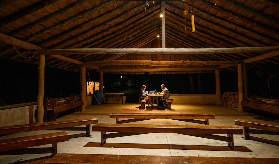 Researchers sift through archeological findings at night in a shelter