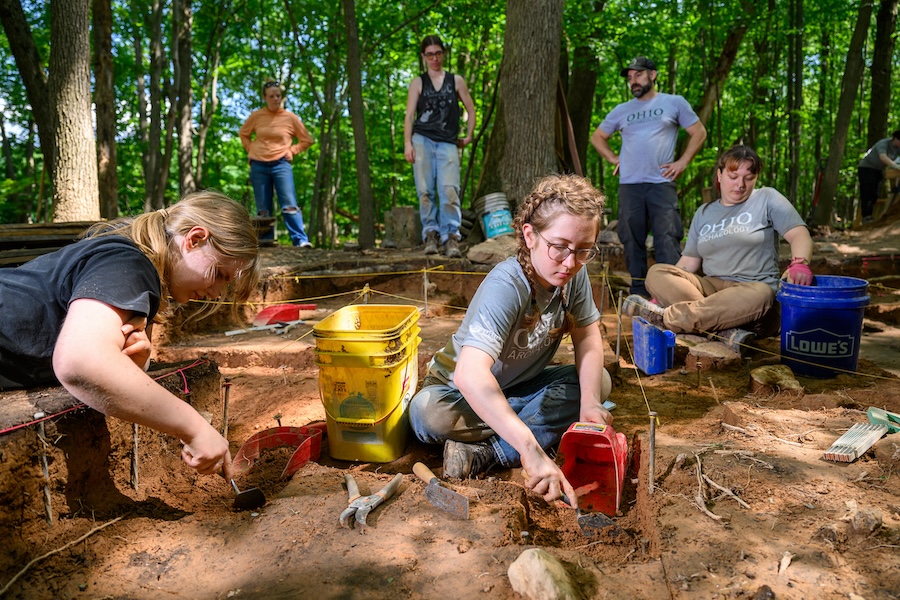 Students work together at an archeological dig
