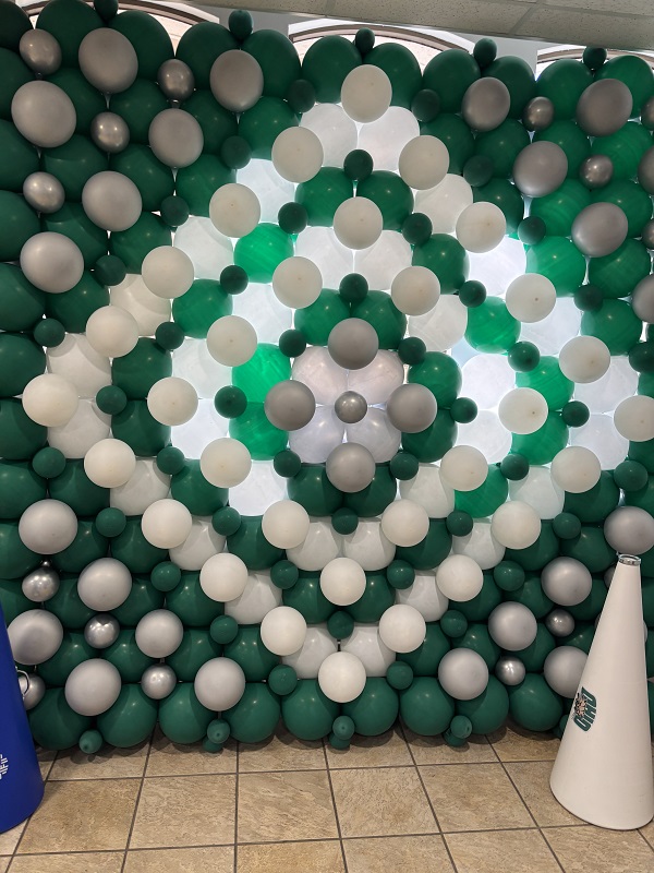 A wall of green and white balloons inside of an OhioHealth building