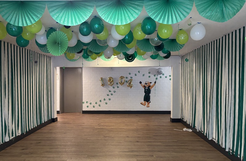A hallway in River park is decorated green and white and has an image of Rufus on a wall