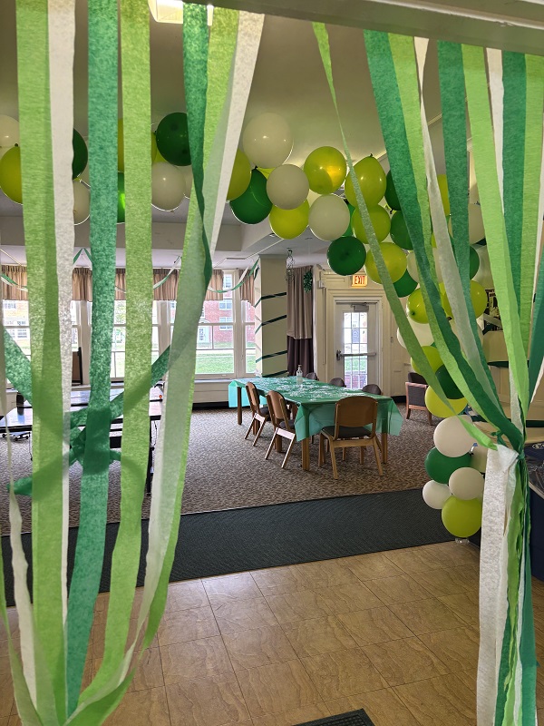 The Tiffin Hall lobby is decorated with green and white balloons, streamers and green table covers