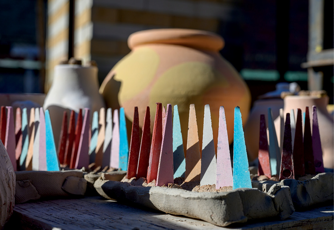 colorful ceramic cones lined up in a tray of sand