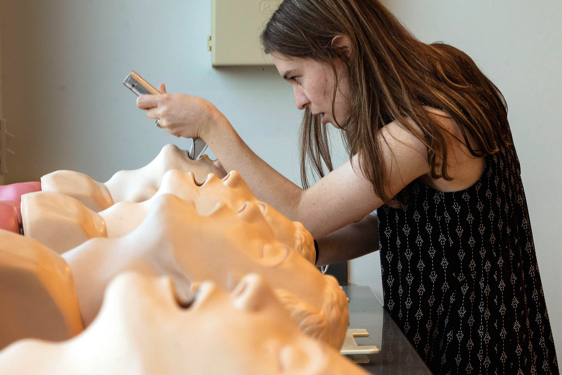 a female student practices intubation technique on a medical dummy