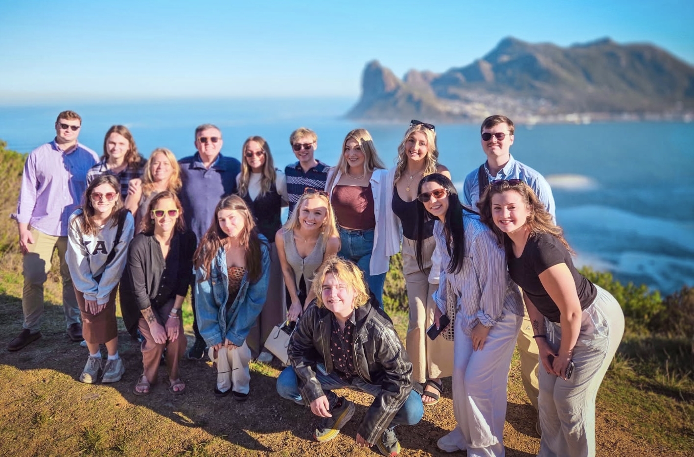 A group of students (the law, justice & culture cohort) standing in front of a large body of water 