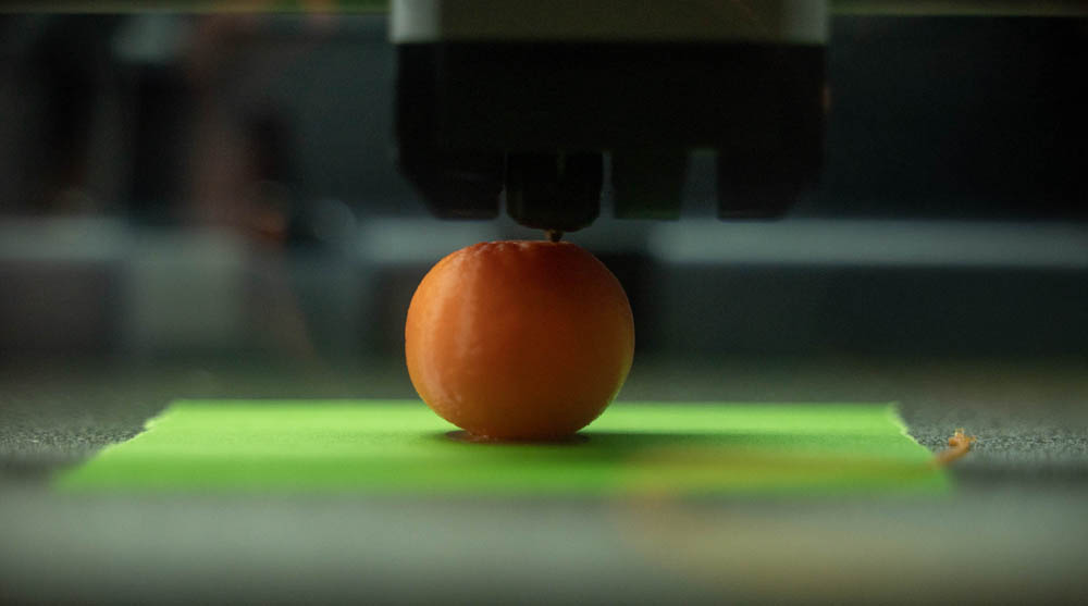 Photo of 3D printer printing an orange