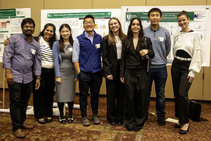 OHIO students stand in front of research posters at the awards event.