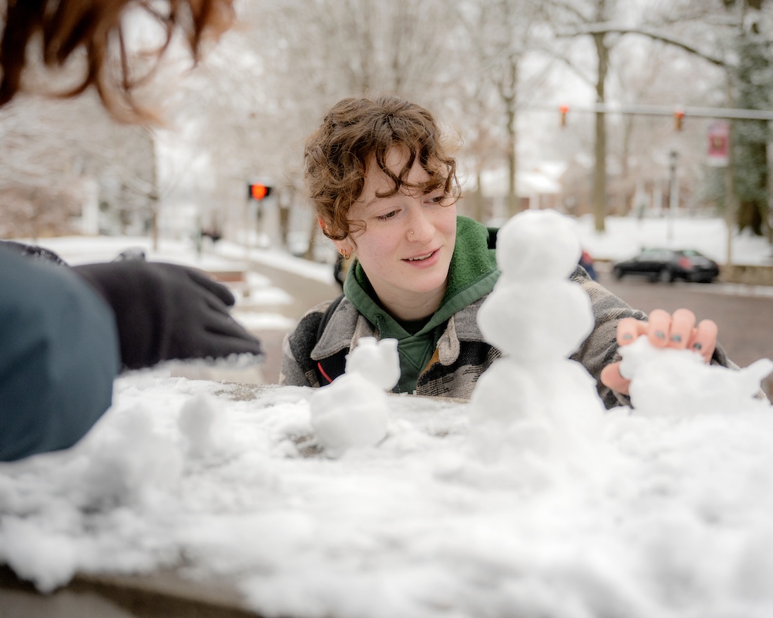 A student builds a mini-snowperson in front of Class Gateway