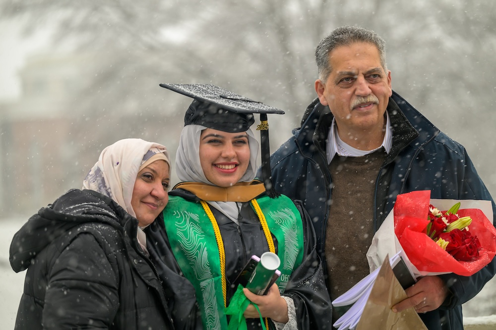 a family poses for a picture in the snow outside Commencement